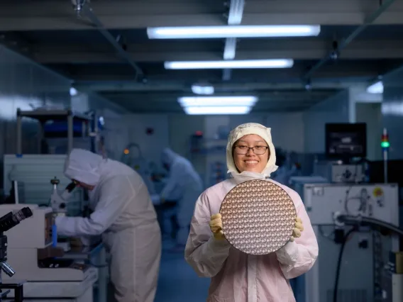 student in bunny suit stands in cleanroom