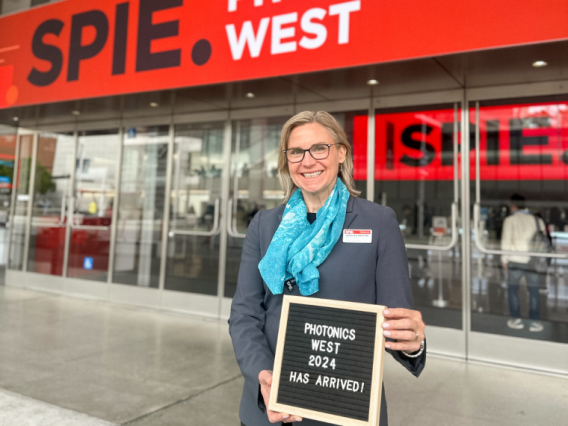Jennifer Barton poses in front of SPIE at Photonics West conference.