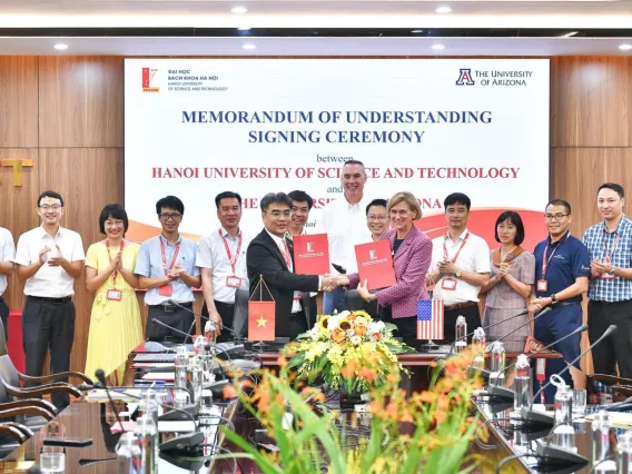 Associate dean of research Mark Van Dyke (center, back) and vice president for semiconductor strategy Liesl Folks (center right, shaking hands) pose for a photo with HUST leaders on Aug. 1, 2024.