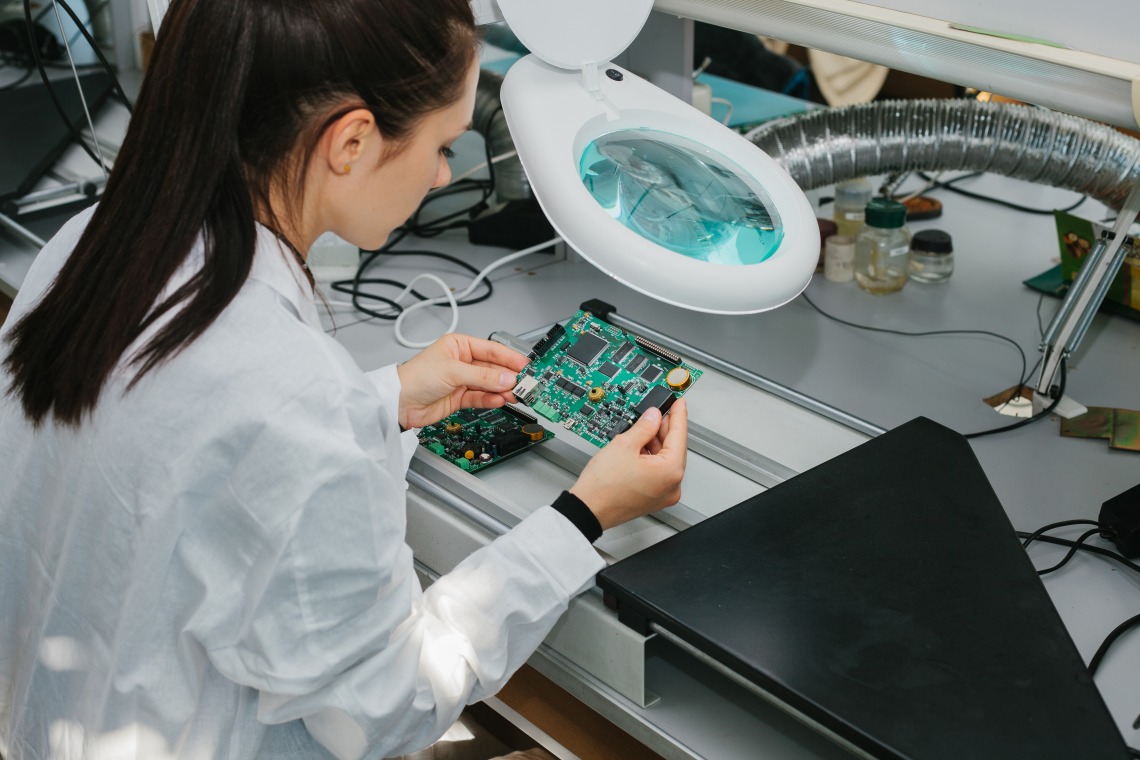 Woman works in Microchip production factory. Technological process.