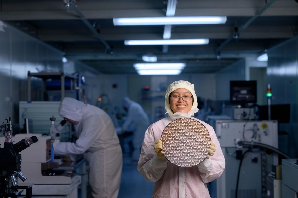 student in bunny suit stands in cleanroom