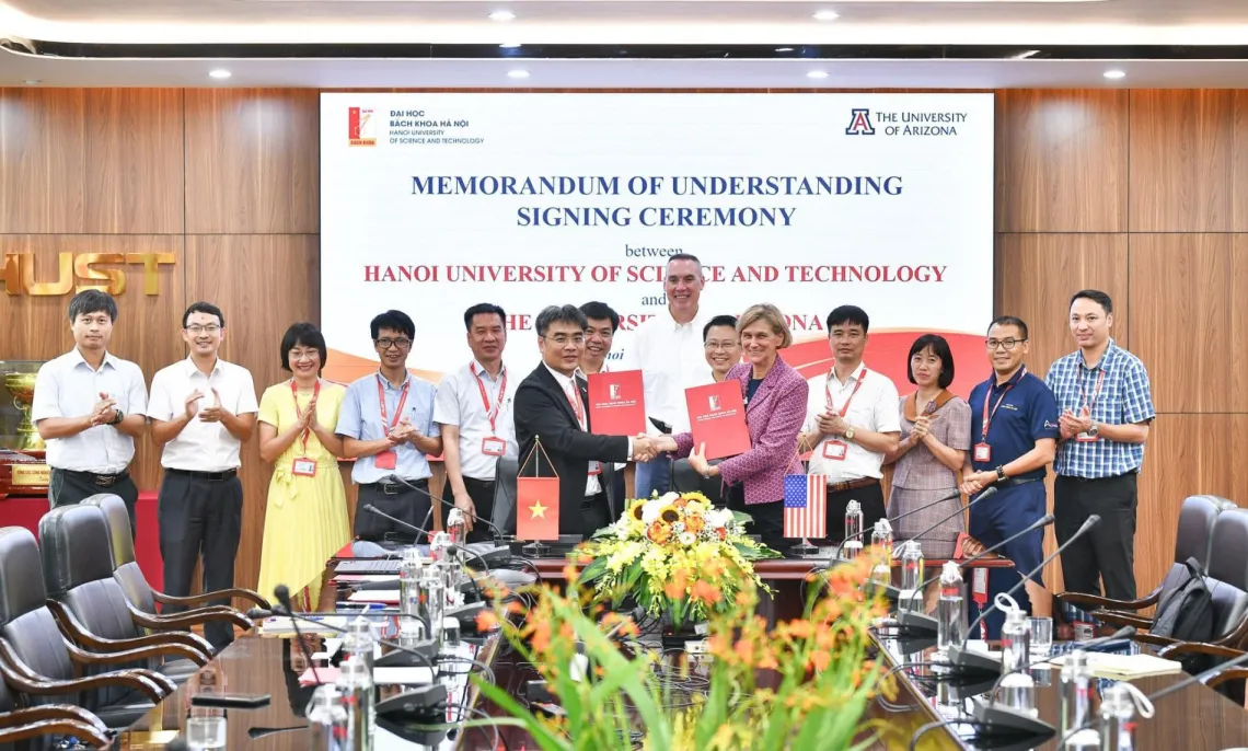 Associate dean of research Mark Van Dyke (center, back) and vice president for semiconductor strategy Liesl Folks (center right, shaking hands) pose for a photo with HUST leaders on Aug. 1, 2024.